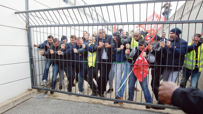Air France union activists break through a gate as they storm the headquarters to disturb a meeting at Roissy Airport, north of Paris, France, Monday, Oct. 5, 2015. Union activists protesting proposed layoffs at Air France stormed the headquarters during a meeting about the job cuts, zeroing in on two managers who had their shirts torn from their bodies, scaled a fence and fled under police protection. (AP Photo/Jacques Brinon)